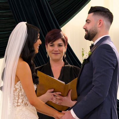 emma and mike at the altar holding hands during their wedding in love is blind season 10