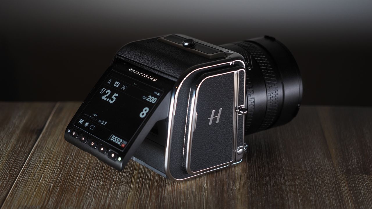The Hasselblad 907X &amp; CFV 100C medium format camera with digital back, on a wooden table with artistic lighting