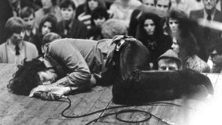 Jim Morrison of The Doors lying on stage at a festival in 1968