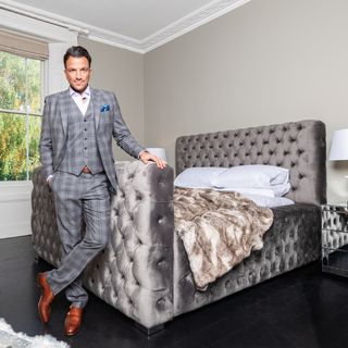 grey bedroom will velvet bed and dark flooring