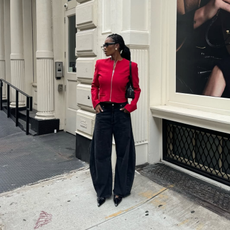 Marilyn wearing a red jacket and black jeans.