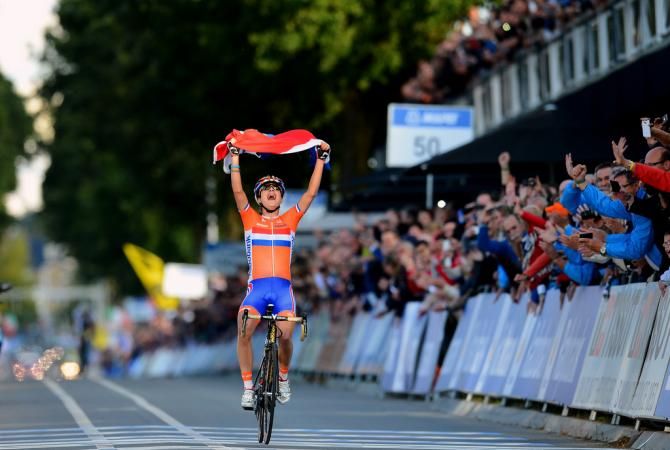 Marianne Vos (Netherlands) has enough time to grab a Dutch flag as she wins the 2012 Worlds