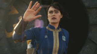 Lucy emerges from Vault 33 with her right hand raised in Amazon's Fallout TV show