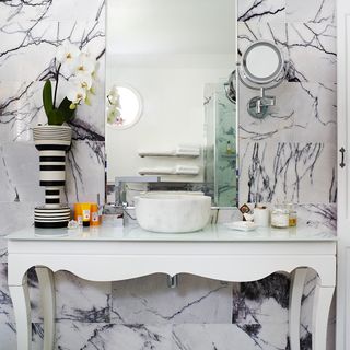 bathroom with marble backdrop and mirror