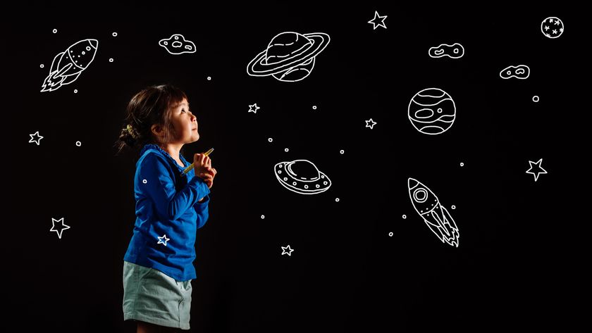 small child drawing astronomy pictures on a black background