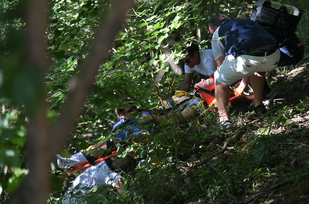 Medical staff move Remco Evenepoel from the site of the crash