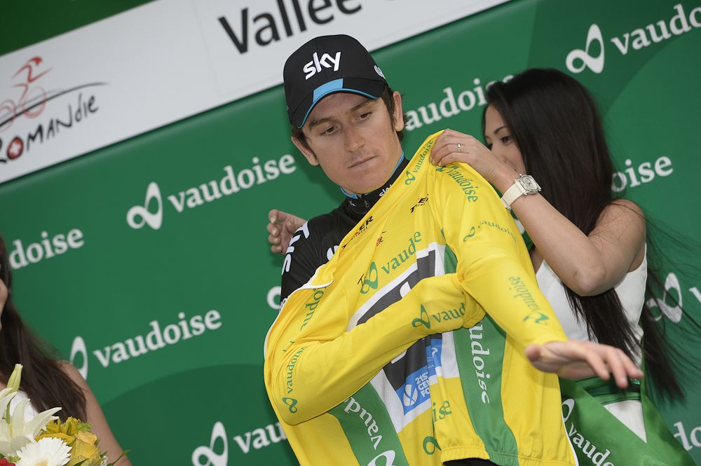 Geraint Thomas pulls on the race leader's jersey.