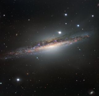 An edge-on view of the spiral galaxy named NGC 1055, located about 55 million light-years from Earth in the constellation of Cetus (the Sea Monster).