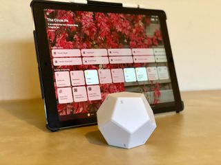 Nanoleaf Remote on a flat surface in front of an iPad