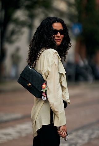 A Woman Wearing The Bag Charm Trend During Milan Fashion Week Spring/Summer 2025.