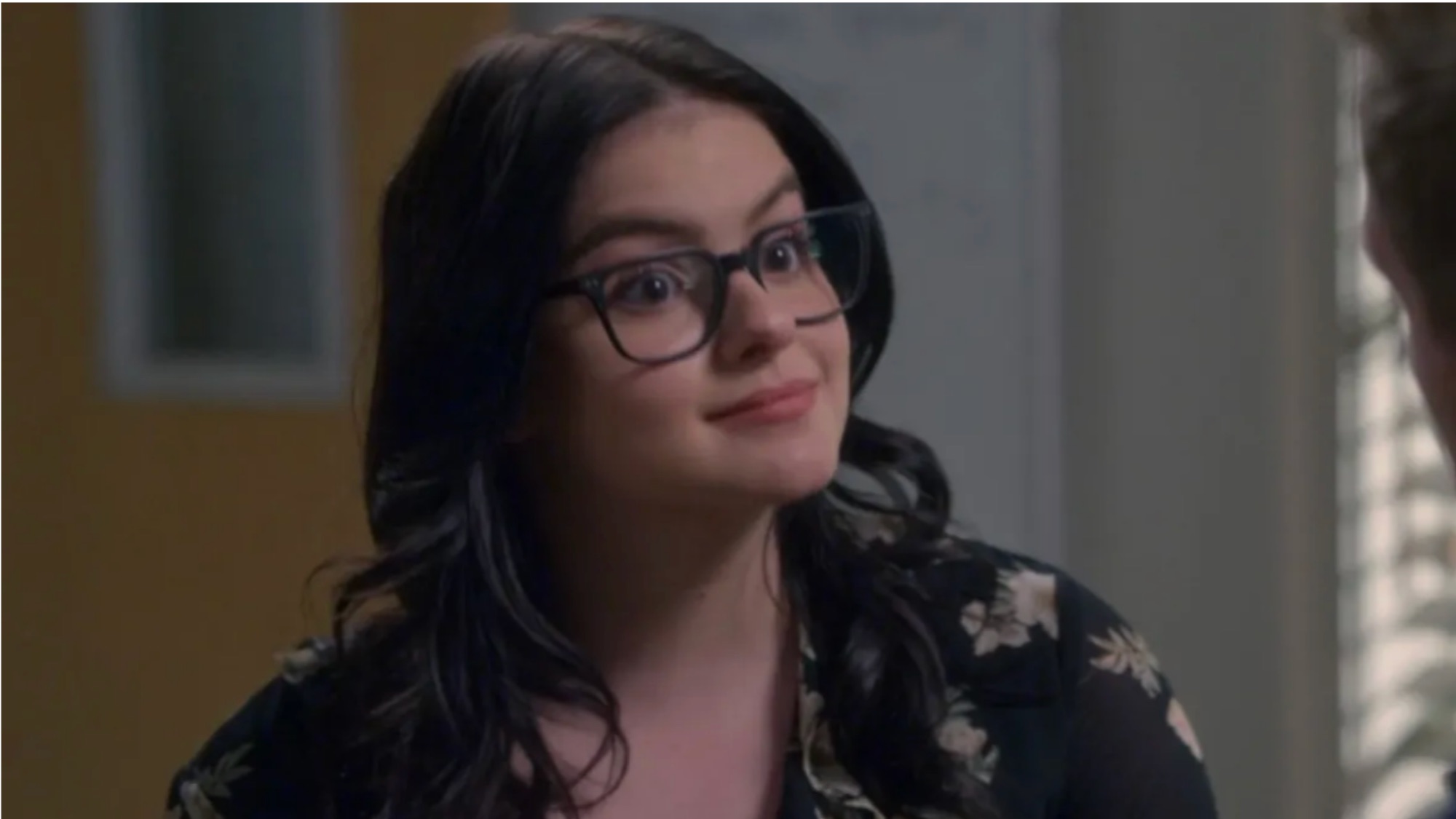 Ariel Winter in Modern Family wearing glasses and a floral shirt. 