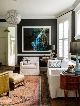 Living room with black walls and white sofas