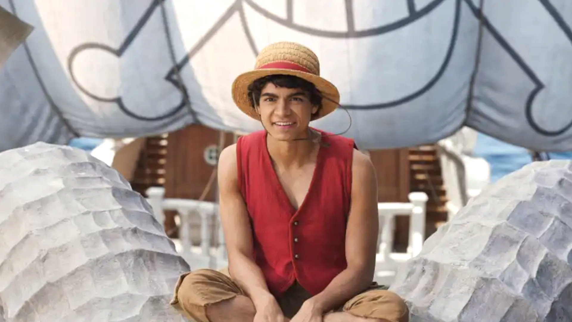 I&amp;ntilde;aki Godoy as Monkey D. Luffy sitting on the mask of the Thousand Sunny during One Piece season 2 on Netflix.