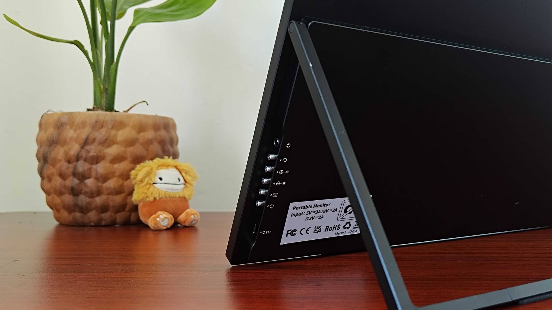Close up of Uperfect Umax 24 portable monitor buttons on desk.