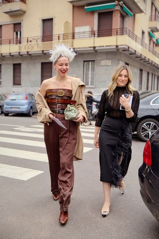 Guest wearing a fringe headpiece with a belted jumpsuit in Milan.