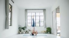 TikTok headstand challenge woman in yoga studio on mat standing on her head