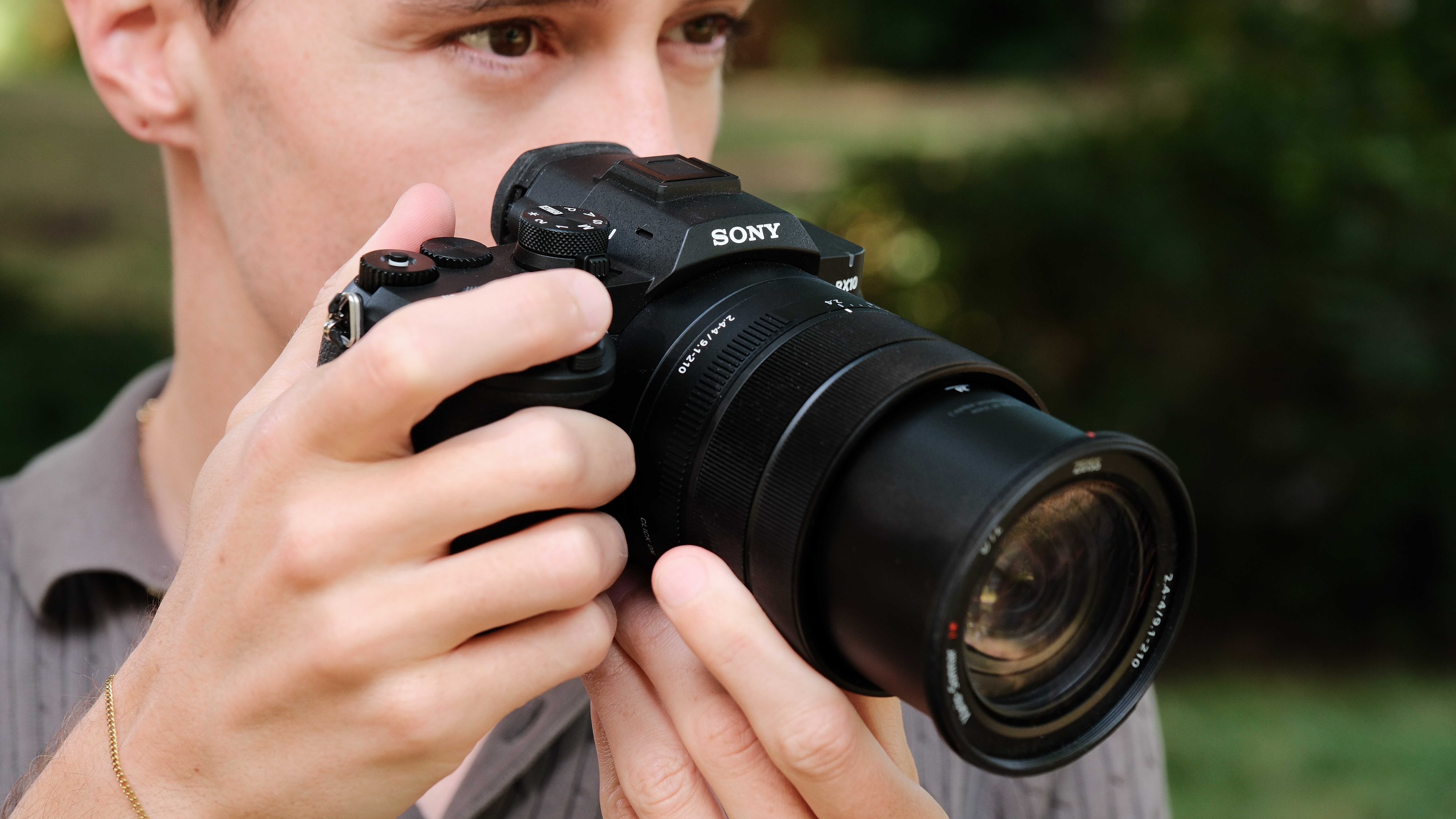 Photographer looking through the Sony RX10 V electronic viewfinder while taking a picture.