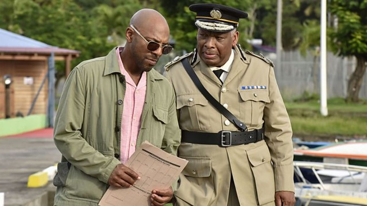 Don Gilet as Detective Inspector Mervin Wilson alongside Don Warrington as Commissioner Selwyn Patterson in Death in Paradise season 14