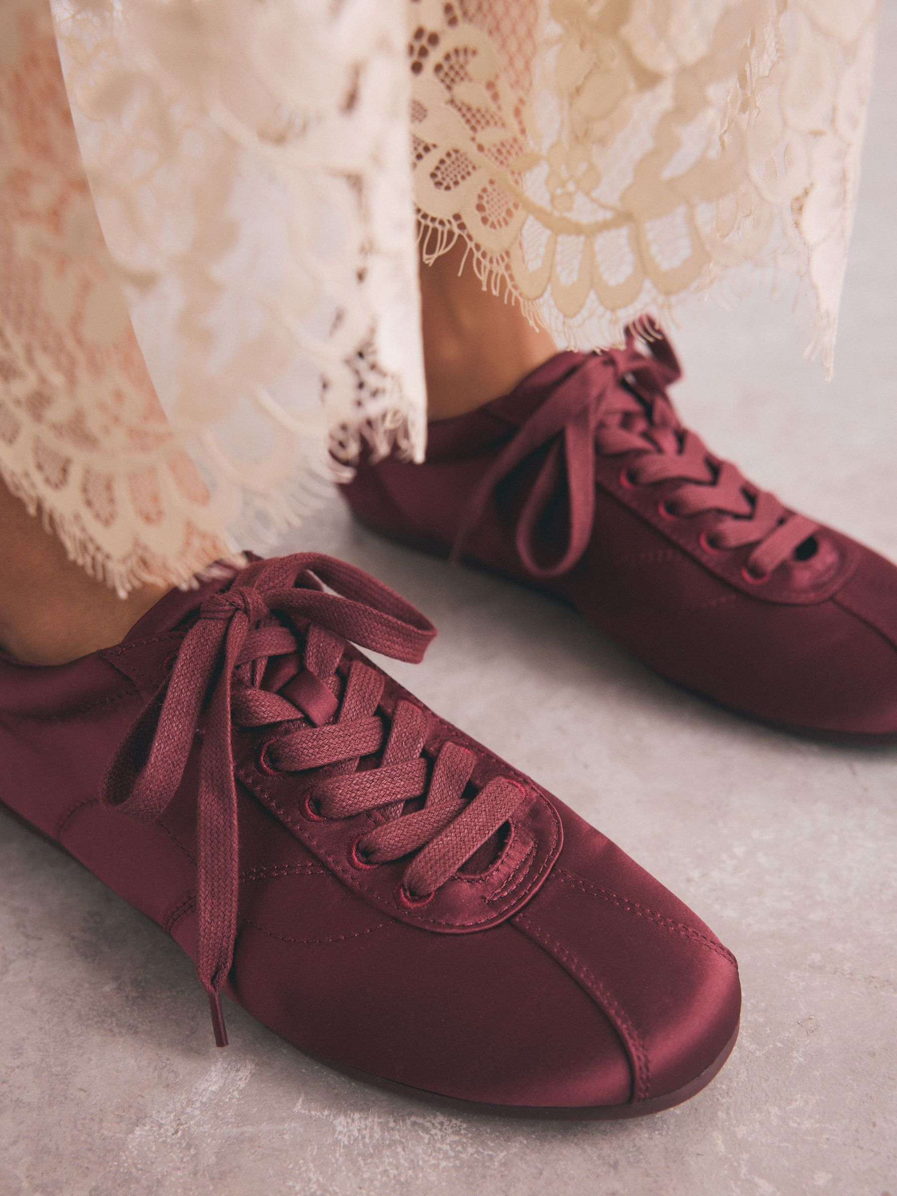 An image of satin trainers from Next.