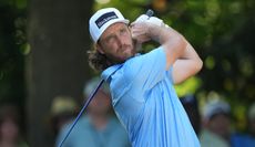 Tommy Fleetwood hits a tee shot and watches its flight