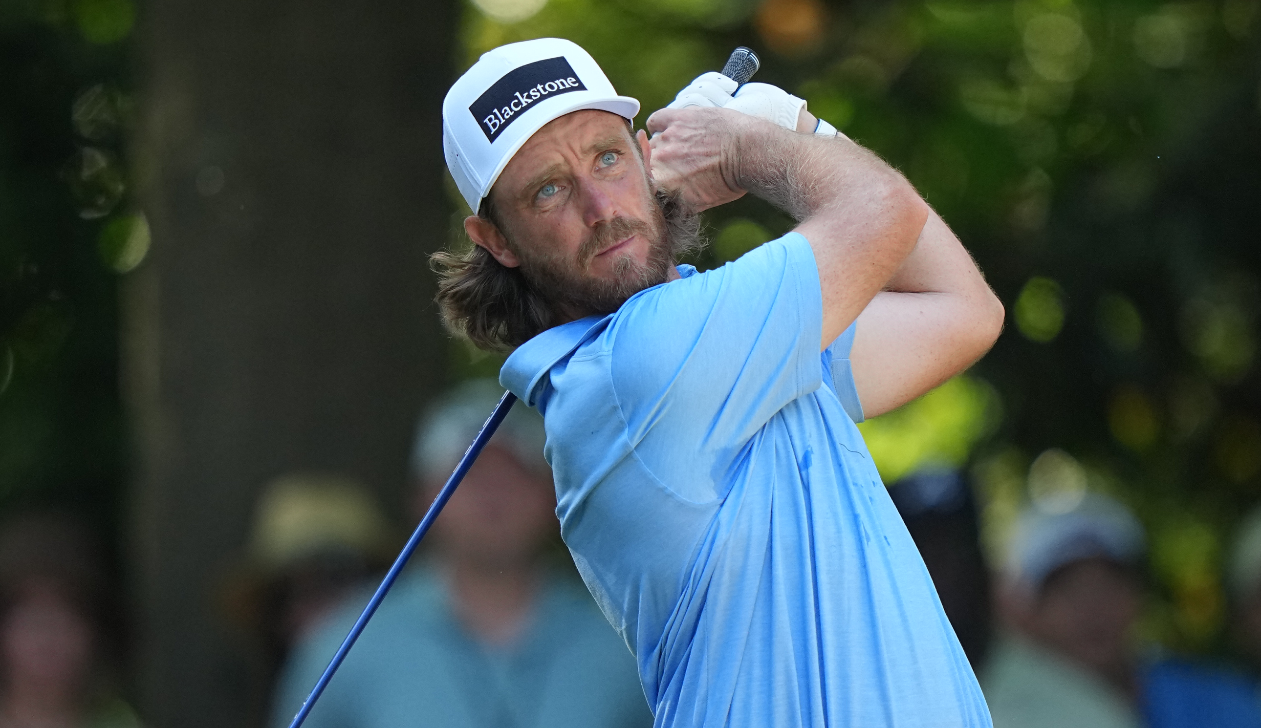 Tommy Fleetwood hits a tee shot and watches its flight