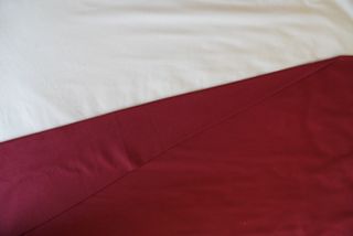 Flat red and white sheets on top of bed