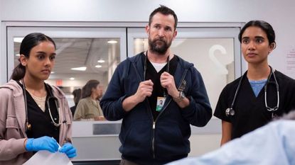 Three doctors stand in a surgery room