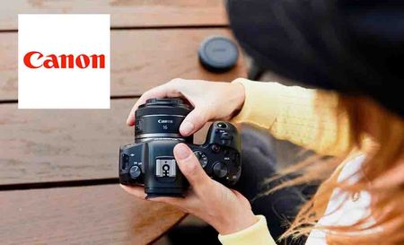 Canon logo at the top left with a top down view of a woman looking at taking off a lens from a DSLR