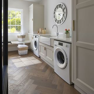 Utility room with herringbone flooring and shaker cabinets.