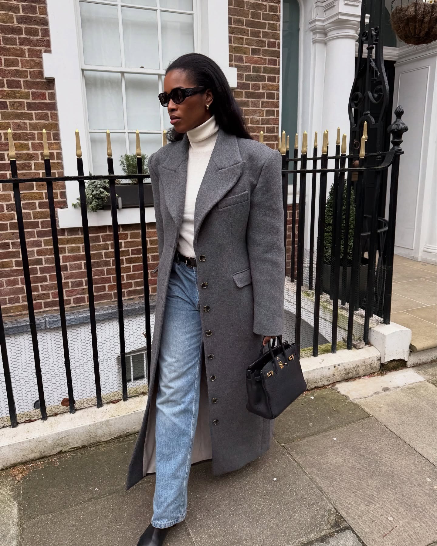 Influencer @nlmarilyn wears a light grey coat with blue jeans.