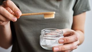 woman using bicarbonate of soda to whiten teeth naturally