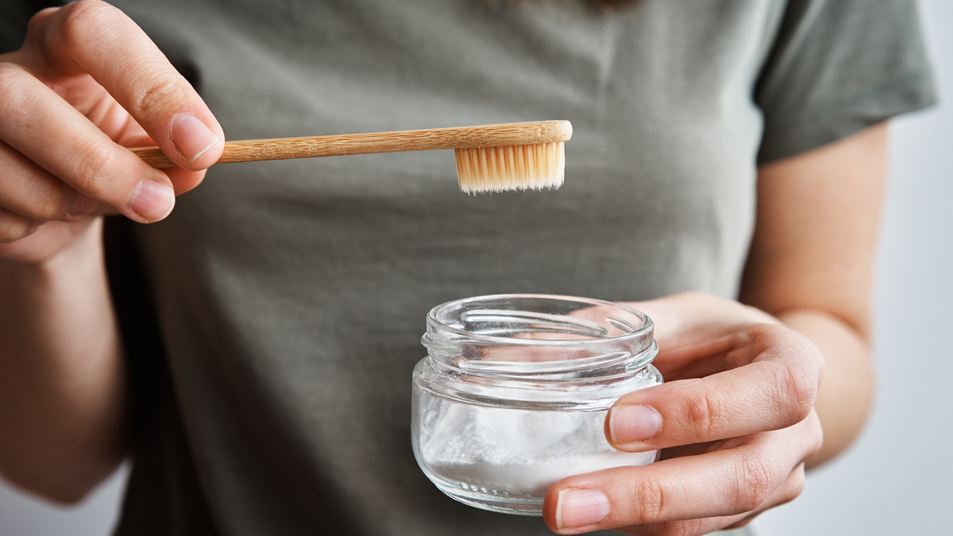 Mujer que usa bicarbonato de sodio para blanquear los dientes de forma natural