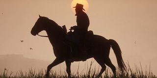 Arthur rides his horse against the setting sun.