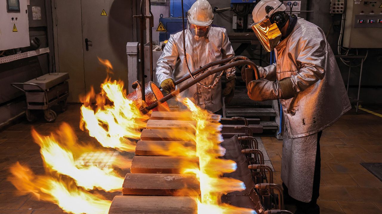 Worker pouring molten gold into moulds