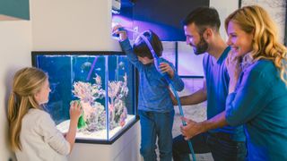 Family cleaning fish tank using one of the best fish tank cleaners