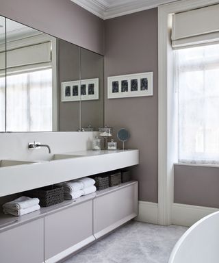 A modern bathroom in shades of gray with a sleek vanity area and a large mirror