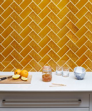 Yellow tiles in a kitchen with lemons and white plates