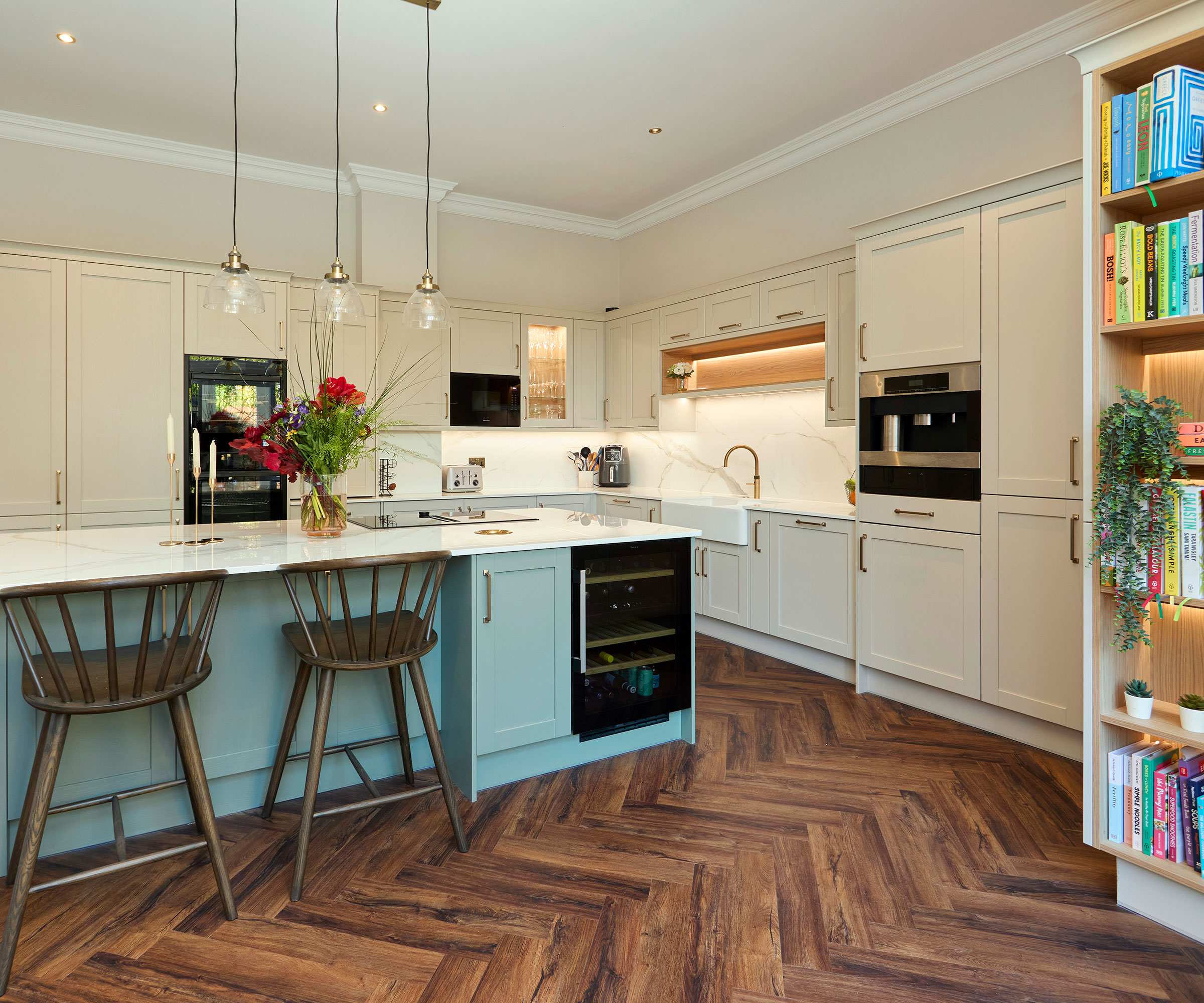 large blue and white kitchen with blue kitchen island and herringbone wood flooring