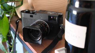 Leica M11-P camera on a wooden surface between two objects