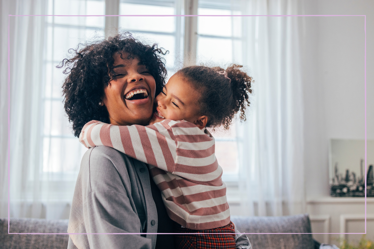 smiling mother being hugged by her young daughter