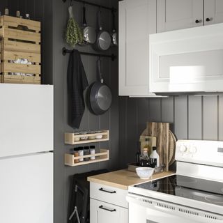 A small kitchen idea with white gloss cabinets, grey walls, wood panelling, wall panelling and hanging cooking utensils