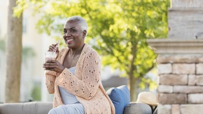 Woman sitting outside drinking a protein shake