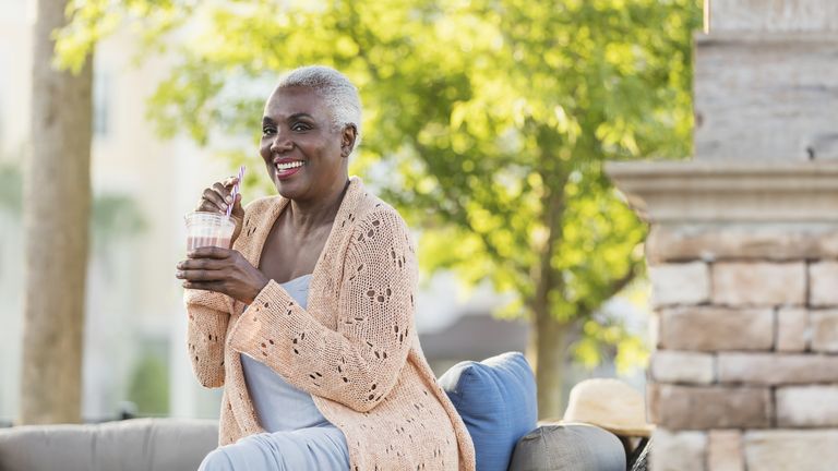 Woman sitting outside drinking a protein shake