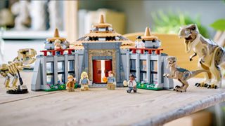 The fully-constructed Lego Visitor Center with all the Minifigures, arrayed on a wooden table