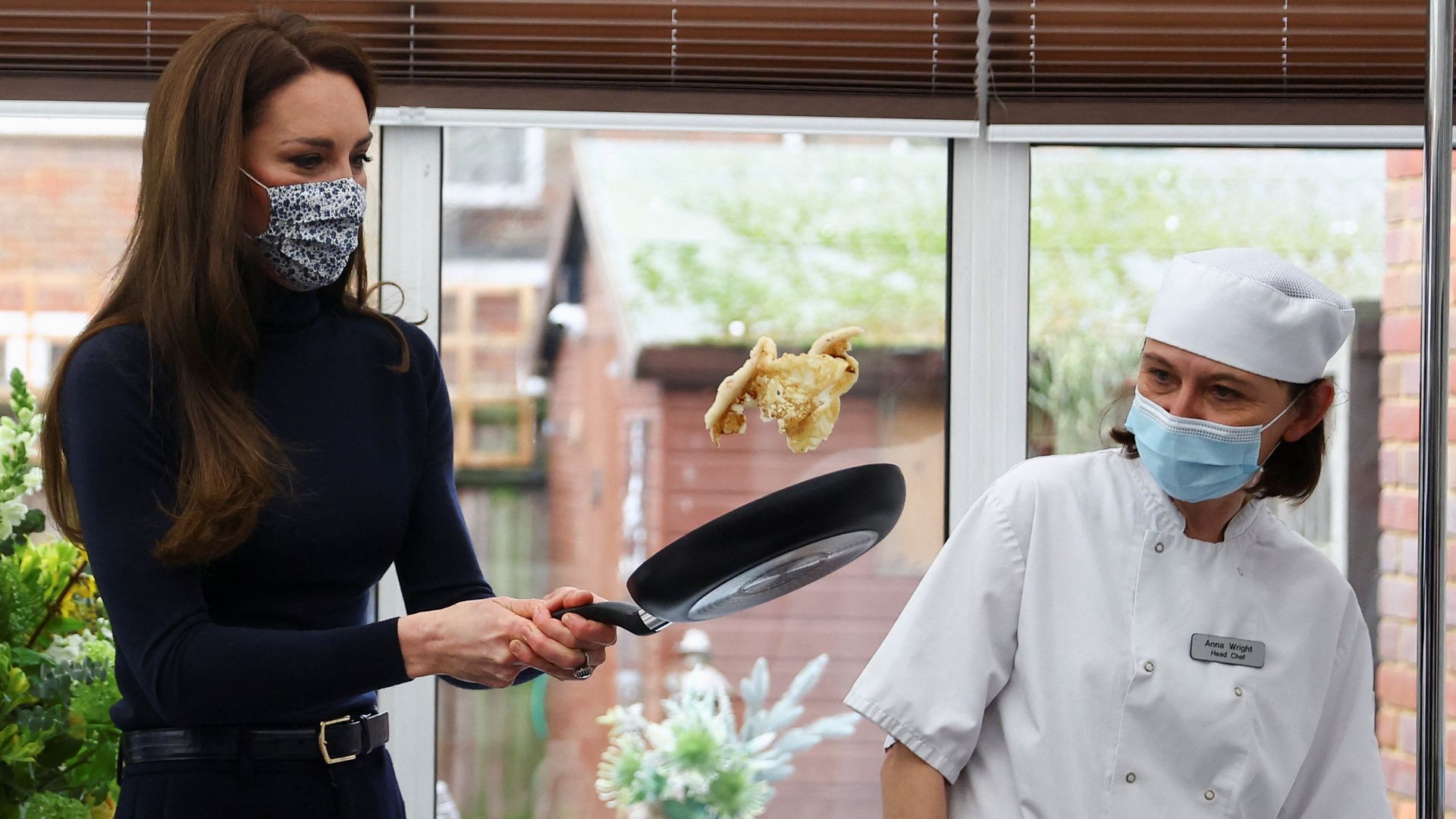 Catherine, Princess of Wales, flips a pancake as she visits the Oxford House Nursing Home in 2023