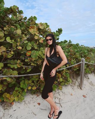 woman wearing silk headscarf and black bikini on vacation