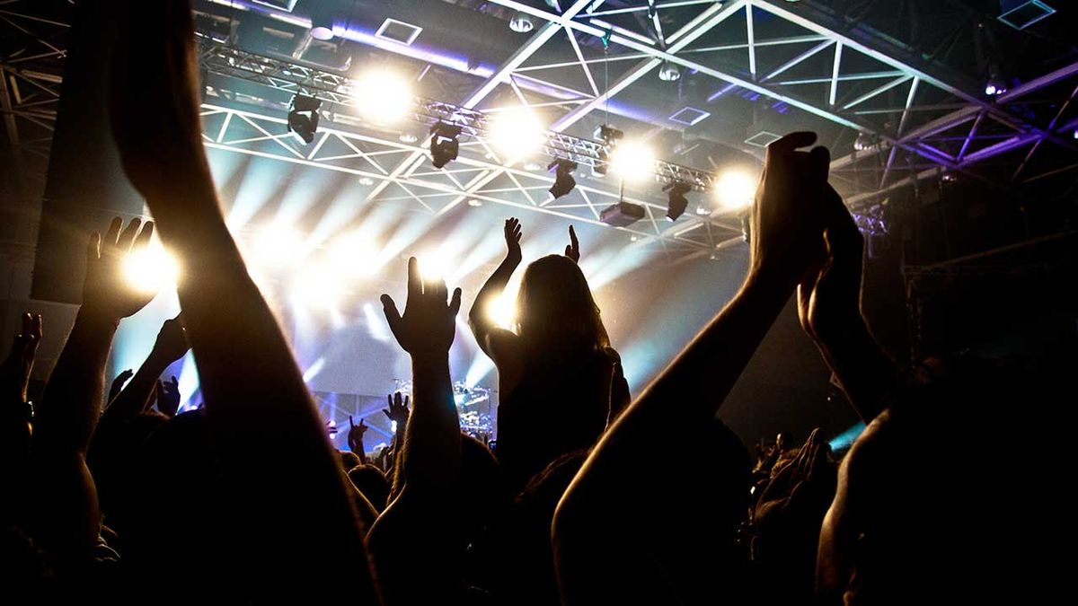 A crowd gather and cheer at a gig