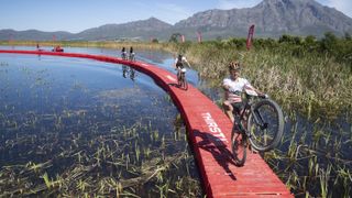 Rider navigating floating bridge at 2021 Absa Cape Epic