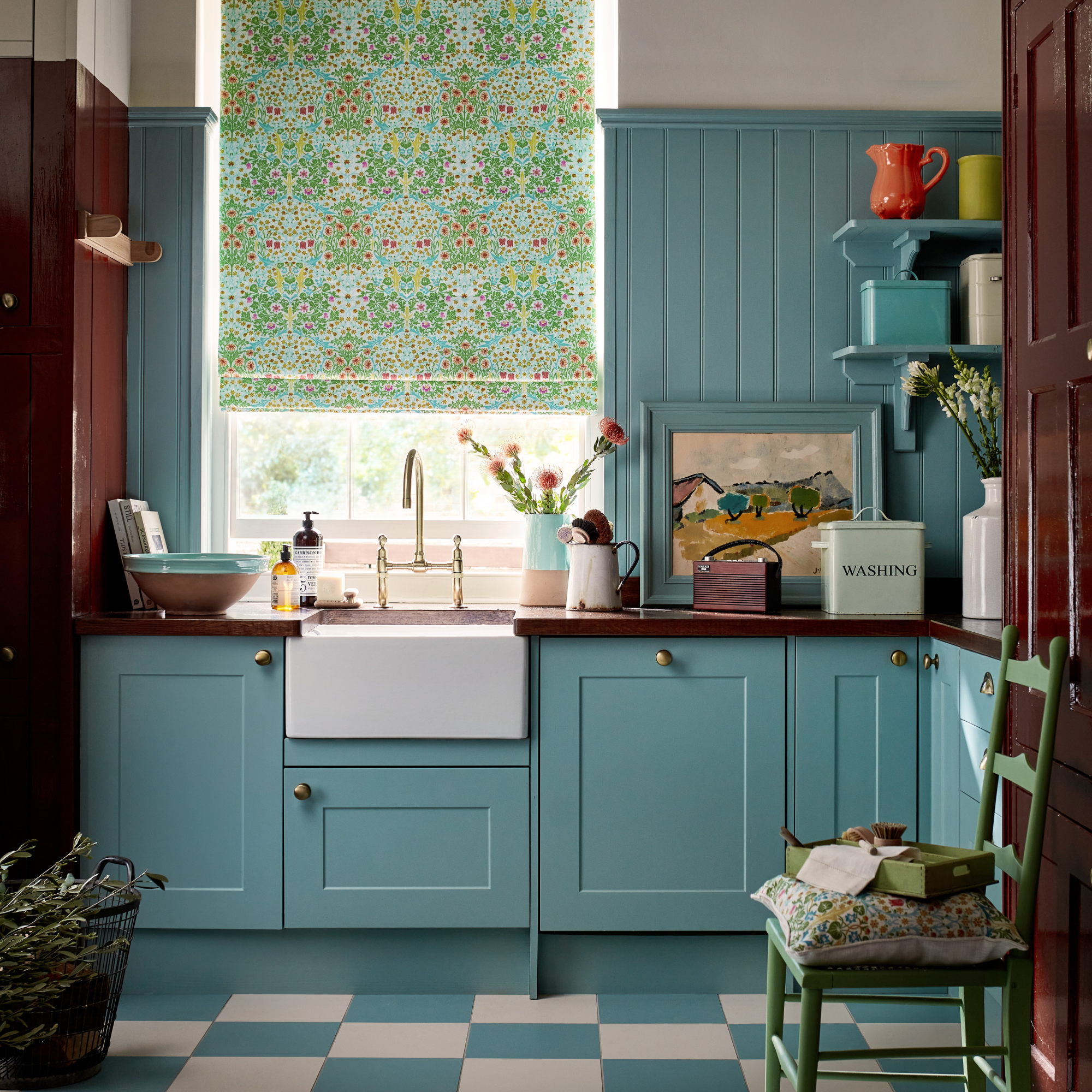 a william morris print blind in a blue kitchen