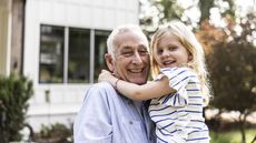 Grandfather and daughter in front of suburban home
